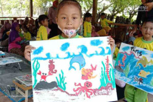 Siswa dari TK Darmawanita 15 menggelar kegiatan melukis dengan tema Konservasi Laut di Balai Eduwisata Pantai Ria Bomo, Desa Bomo, Kec. Blimbingsari, Kab. Banyuwangi.